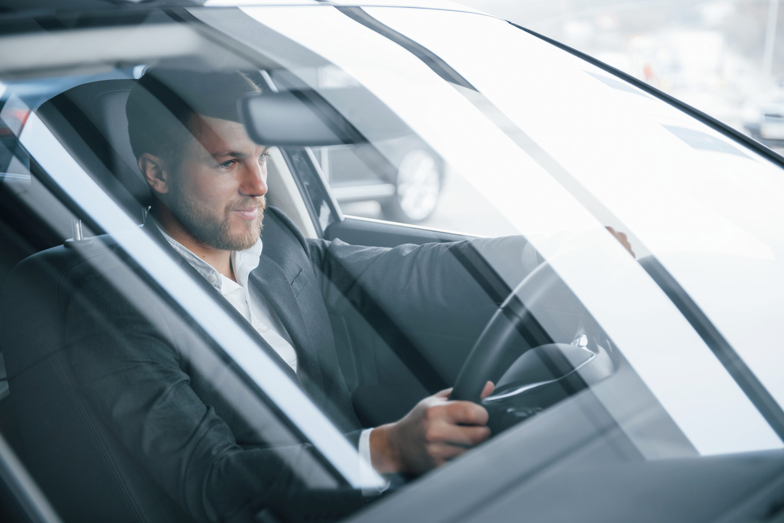 uomo prova la sua nuova automobile in concessionaria