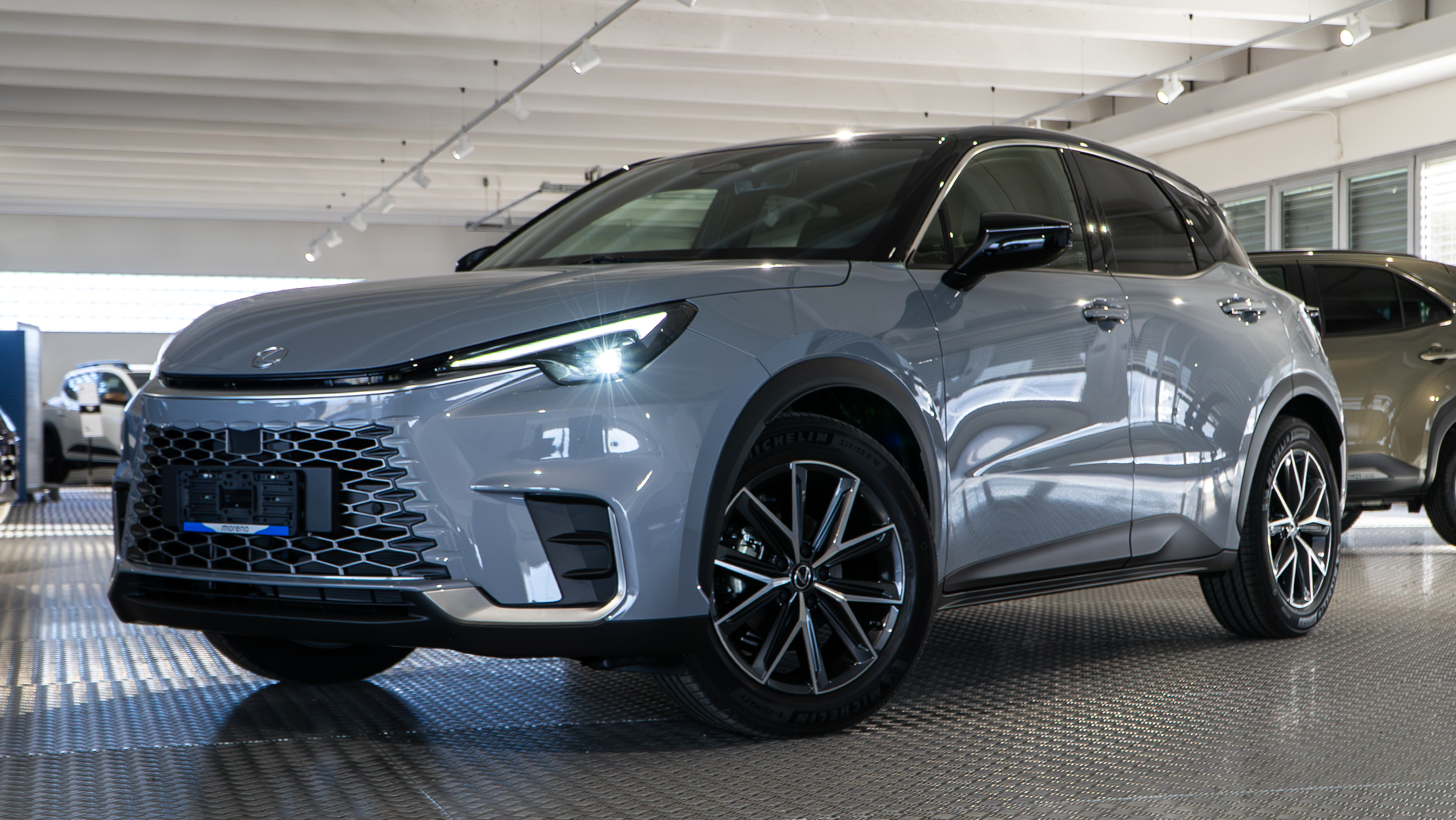 Lexus LBX grigia in un salone auto