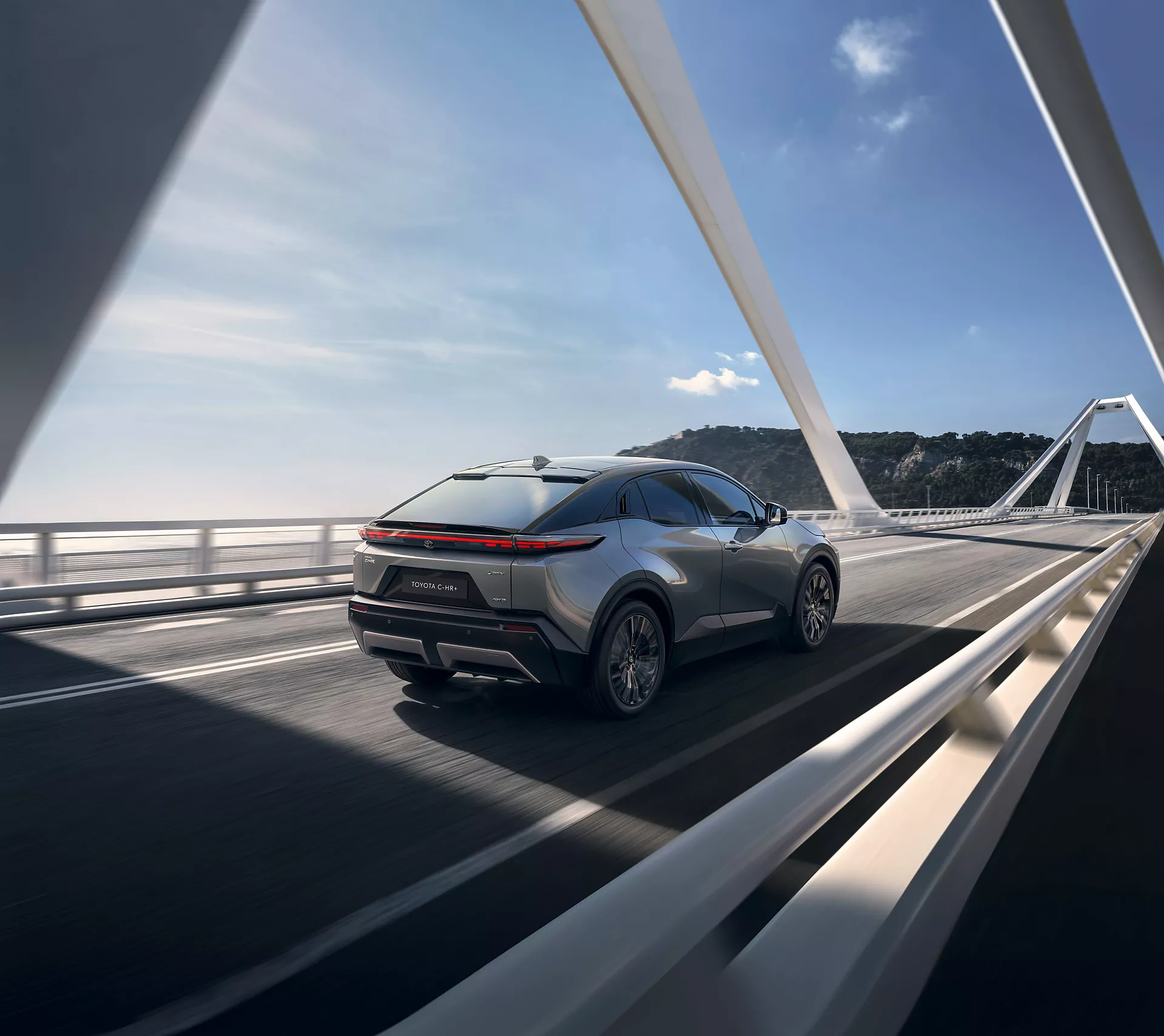 veduta posteriore della Toyota C-HR+ in viaggio su un ponte autostradale 